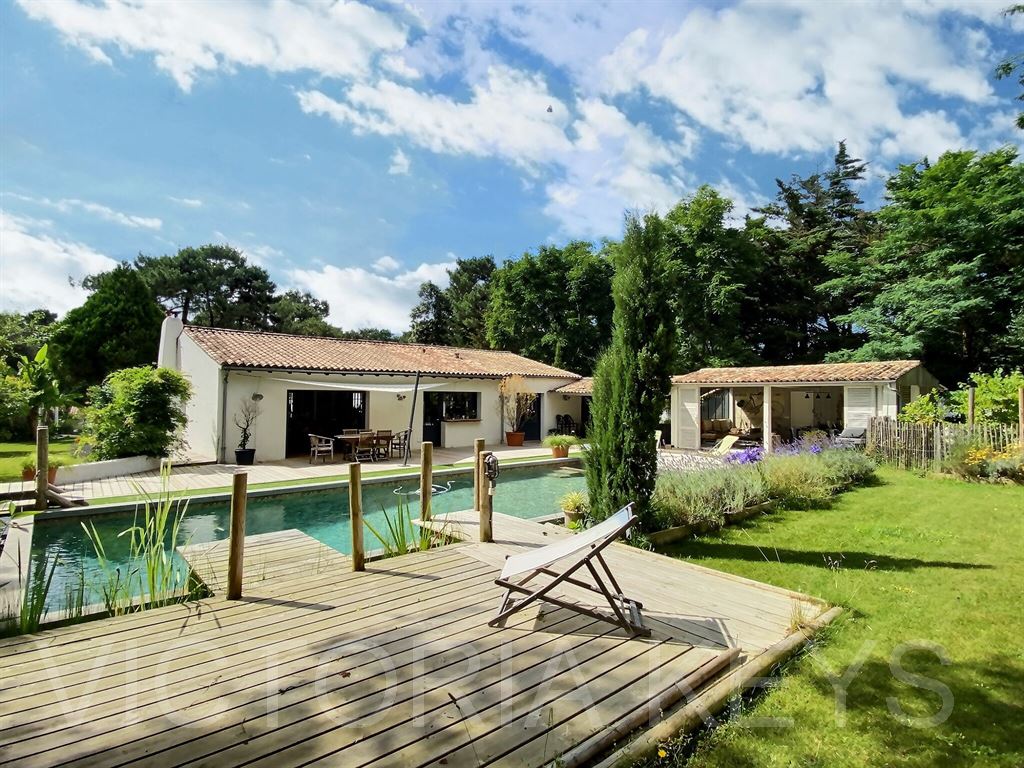 Sur une parcelle arborée de plus de 3000 m2 idéalement située dans la pinède, propriété de 218 m2 offrant une grande entrée, un vaste séjour ouvert sur le jardin et la piscine, une cuisine ouverte aménagée et équipée. 3 chambres et 2 salles d'eau/bains dont une suite parentale avec dressing. Une 4ème chambre avec sa salle d'eau en annexe. Un 2ème petit salon avec un poêle. Autour de la maison s'articule un superbe jardin composé d'une piscine, de terrasses, de bassins et un préau avec une cuisine d'été. À l'avant de la propriété se trouve un garage, un atelier, un carport et de nombreux stationnements.