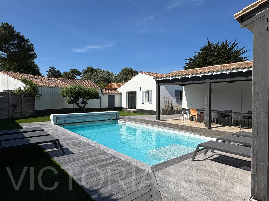 Maison de plain-pied, au calme, proche du port. Sur une parcelle de 1038m2, 170 m2 habitables offrant une maison principale, séjour avec cuisine séparée aménagée et équipée, un espace bureau, 3 chambres, une salle d’eau/ bains. 
Une annexe avec une pièce de vie, cuisine ouverte, deux chambres dont une avec mezzanine. Une salle d’eau. 
Jardin avec piscine chauffée, un grand préau et stationnements. Bonne exposition.  Immobilier Ile de Ré, maison à vendre - RIVEDOUX-PLAGE